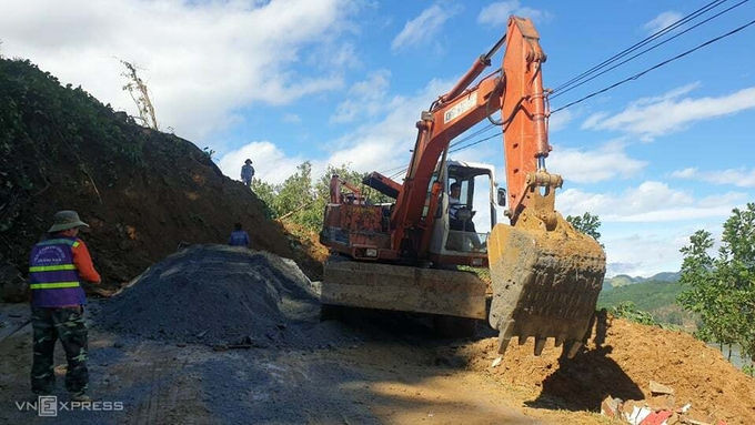 Máy xúc san gạt đất đá mở đường vào xã Trà Leng, sáng 29/10. Ảnh: Đắc Thành