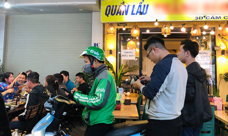 Khách hàng chọn đi&nbsp;xe ôm công nghệ sau khi nhậu xong. Ảnh: Anh Tú.