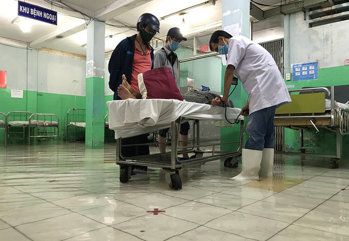 Bác sĩ phải mang ủng khám cho bệnh nhân. Ảnh: Đình Văn.