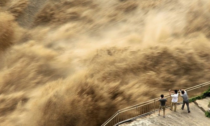 Người dân theo dõi cảnh xả lũ đập Tam Môn Hạ ở tỉnh Hà Nam, Trung Quốc hôm 30/6. Ảnh: AP.