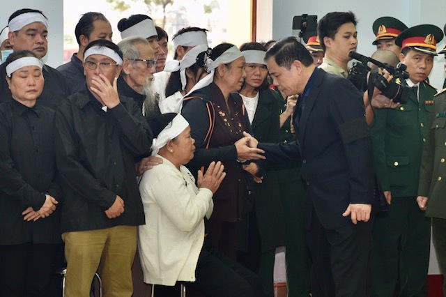 Bộ trưởng Bộ Nông nghiệp và Phát triển nông thôn Nguyễn Xuân Cường chia buồn với thân nhân, gia đình các liệt sĩ. Ảnh: VGP/Nhật Bắc