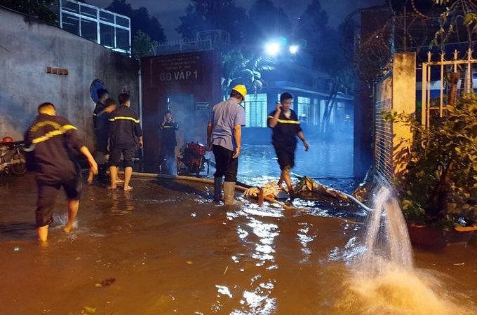 Cảnh sát dùng máy bơm hút nước trong trạm biến áp ra ngoài. Ảnh: Đình Văn.