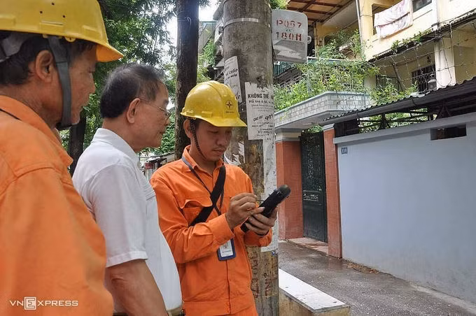 Nhân viên ngành điện đo công tơ điện tử bằng thiết bị đo từ xa. Ảnh: Anh Minh.