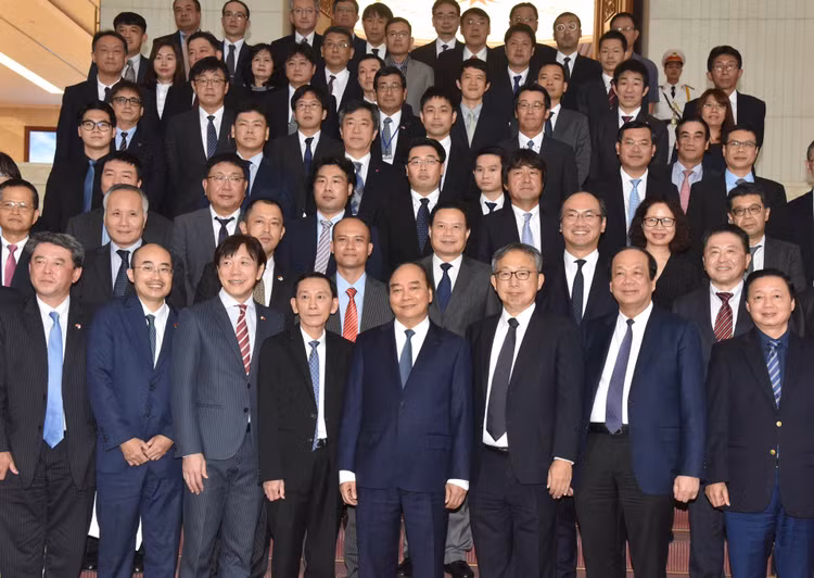 Thủ tướng chụp ảnh lưu niệm với 15 doanh nghiệp được lựa chọn trong Dự án hỗ trợ của Chính phủ Nhật Bản để đa dạng hóa nguồn cung cho chuỗi cung ứng ở nước ngoài - Ảnh: VGP/Quang Hiếu