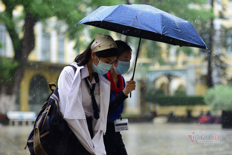 Thí sinh đến trường thi môn Toán trong cơn mưa