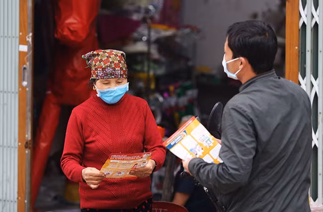 Cán bộ xã Sơn Lôi (Bình Xuyên, Vĩnh Phúc) phát tờ rơi phòng chống viêm đường hô hấp cấp do covid-19 cho người dân. Ảnh: Tất Định&nbsp;
