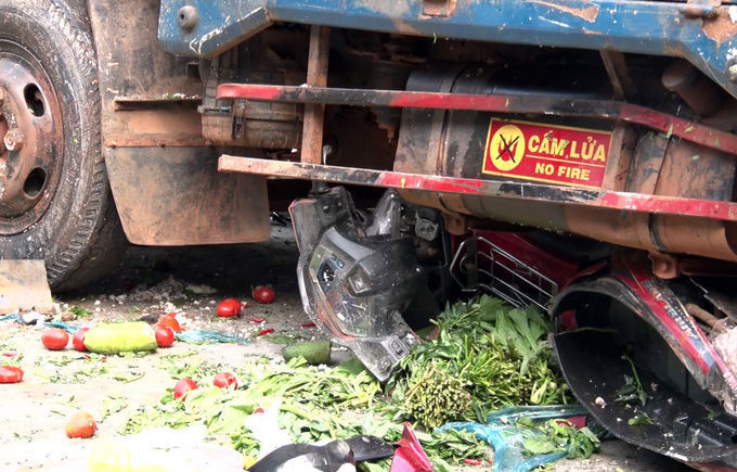 Một xe máy của nạn nhân bị cuốn dưới gầm xe tải. Ảnh: Trần Hóa.