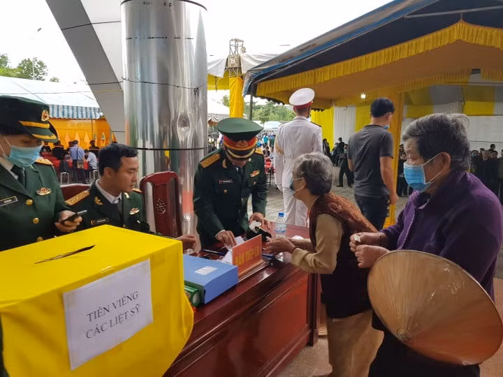 Nhiều người dân tại thành phố Đông Hà không quản mưa lạnh đến phúng viếng các liệt sĩ hy sinh vì nhiệm vụ. - Ảnh: VGP