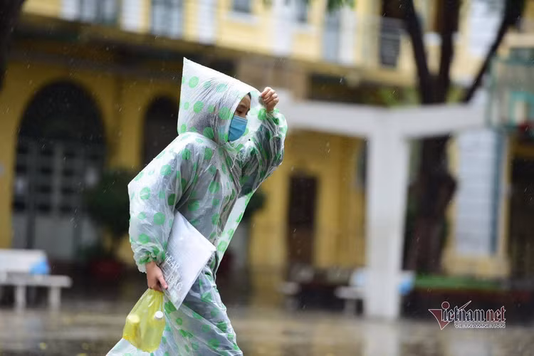 Thí sinh đến trường thi môn Toán trong cơn mưa