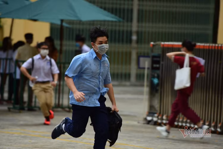 Thí sinh đến trường thi môn Toán trong cơn mưa