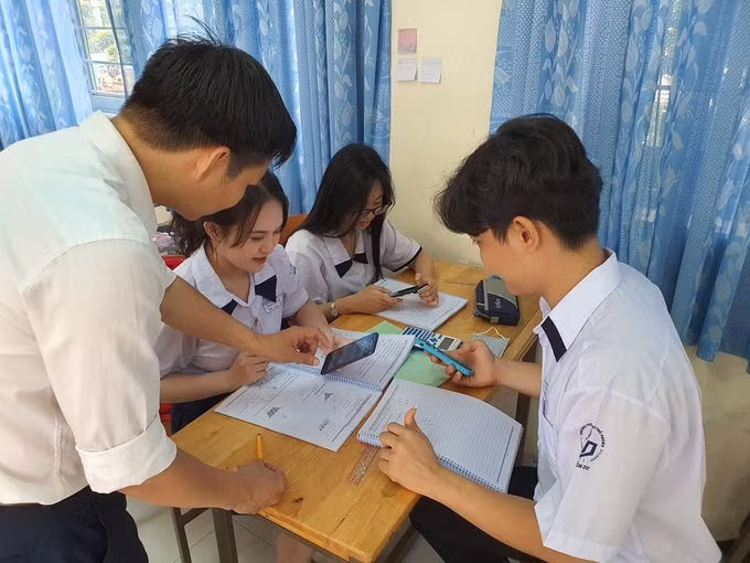 Học sinh trường THPT Nguyễn Du (quận 10, TP HCM) trong một tiết học có sử dụng điện thoại dưới sự hướng dẫn của giáo viên. Ảnh: Huỳnh Phú