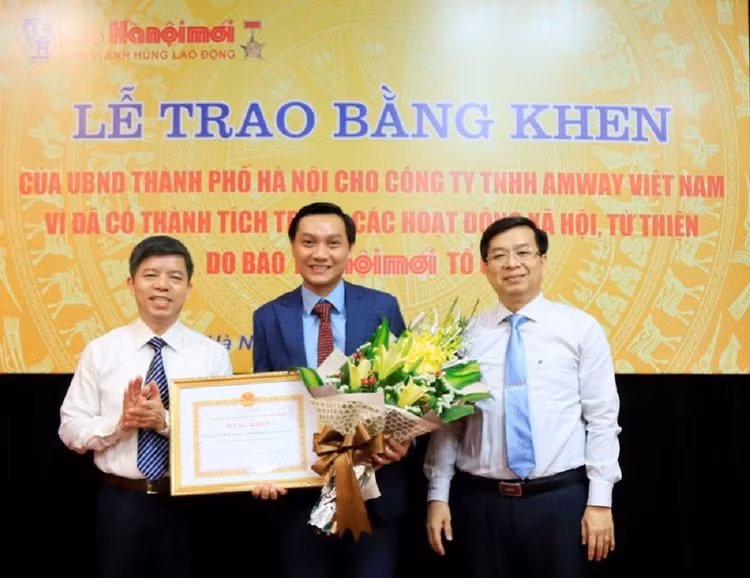 Phó Trưởng ban Thi đua - Khen thưởng TP Hà Nội Đinh Việt Thắng và Tổng Biên tập Báo Hànộimới Nguyễn Hoàng Long trao Bằng khen cho đại diện Công ty TNHH Amway Việt Nam.