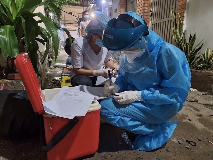 Nhân viên y tế quận Gò Vấp lập danh sách, chuẩn bị lấy mẫu xét nghiệm các trường hợp liên quan tại nơi sinh hoạt của Hội thánh Truyền giáo Phục Hưng, ở đường Nguyễn Văn Công, tối 26/5. Ảnh: HCDC.