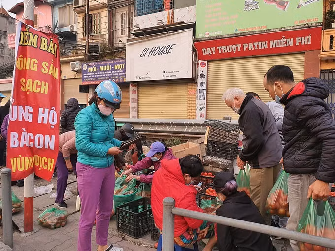 Người dân mua ủng hộ nông sản Hải Dương lúc 7h sáng 21/2 tại 38 Giải Phóng (Hà Nội). Ảnh: Đức Minh.