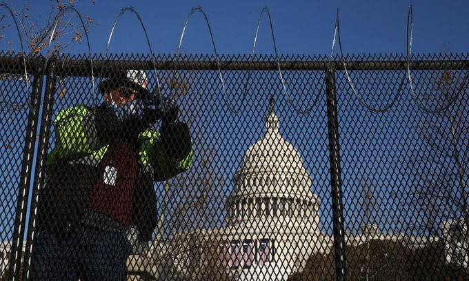 Công nhân lắp hàng rào và lưới thép gai quanh Đồi Capitol hôm 14/1. Ảnh: AFP.