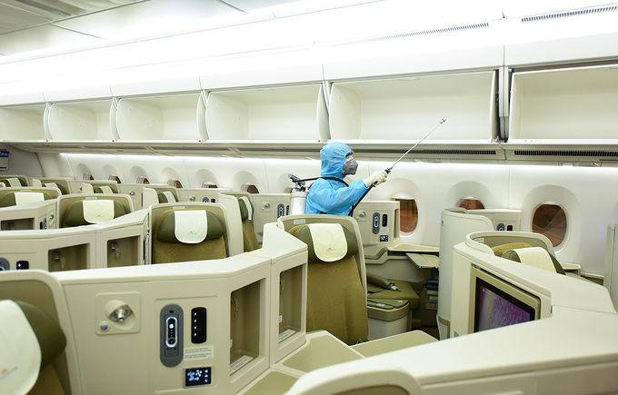 Nhân viên y tế khử trùng máy bay tại sân bay Nội Bài, tháng 3/2020. Ảnh: Giang Huy