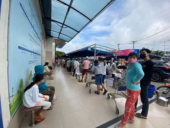 Hệ thống online, siêu thị quá tải khi hơn nửa chợ đóng cửa ảnh 1 Khách xếp hàng dài chờ tới lượt vào mua hàng ở Co.opmart Xa lộ Hà Nội. Ảnh: Tấn Đạt.