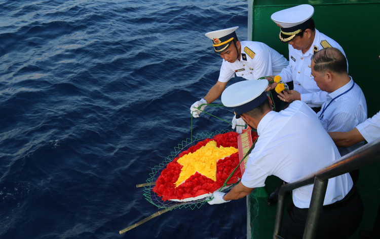 Các thành viên đoàn công tác thả vòng hoa, hoa và hạc giấy để tưởng niệm các anh hùng, liệt sĩ