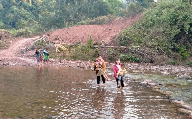 Buổi sáng cô Kim cùng đồng nghiệp đón học sinh qua suối đến lớp. Ảnh: NVCC