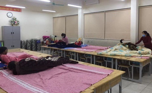 23h30 ngày 30/1, các phụ huynh, học sinh lớp 3E trường tiểu học Xuân Phương kê bàn ghế thành bốn giường để nghỉ ngơi và sinh hoạt. Ảnh: Nhân vật cung cấp.