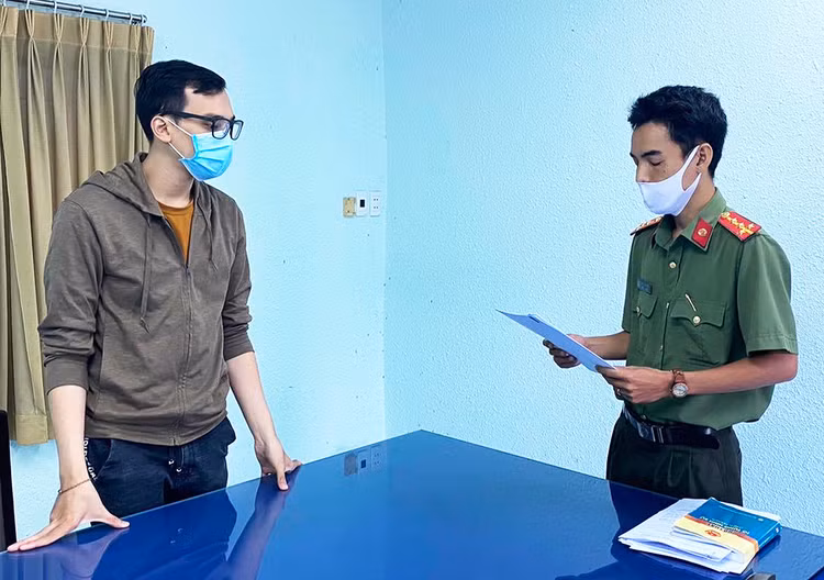 Cơ quan an ninh điều tra tống đạt quyết định khởi tố. Ảnh: Công an cung cấp.