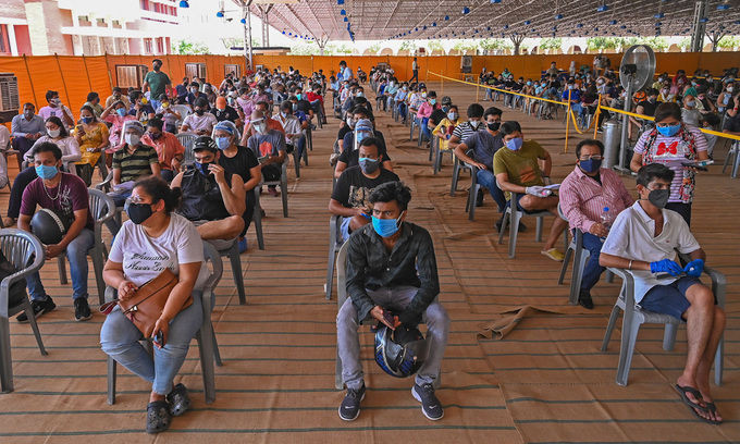 Người dân ngồi chờ tiêm vaccine Covid-19 tại một bệnh viện ở New Delhi tuần trước. Ảnh: AFP.