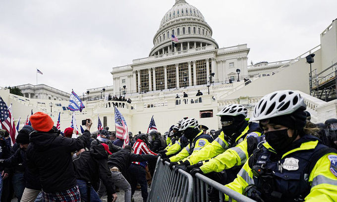 Người biểu tình ủng hộ Trump cố gắng phá hàng rào bảo vệ của cảnh sát trước tòa nhà quốc hội Mỹ hôm 6/1. Ảnh: AP.