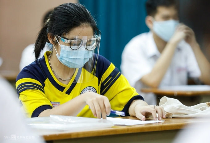 Một thí sinh đeo kính chắn giọt bắn trong buổi làm thủ tục dự thi tốt nghiệp THPT ở TP HCM, chiều 6/7. Ảnh: Hữu Khoa