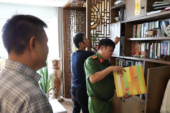 Ông Trần Huy Lập (trái) chứng kiến cơ quan điều tra khám xét. Ảnh: Công an Đồng Nai.