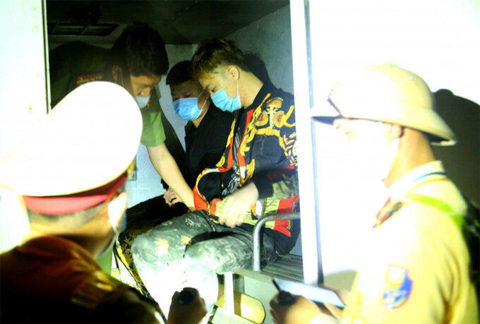 Hai người Trung Quốc trốn cách ly được cảnh sát bàn giao cho nhà chức trách Nghệ An xử lý. Ảnh: Hùng Cường