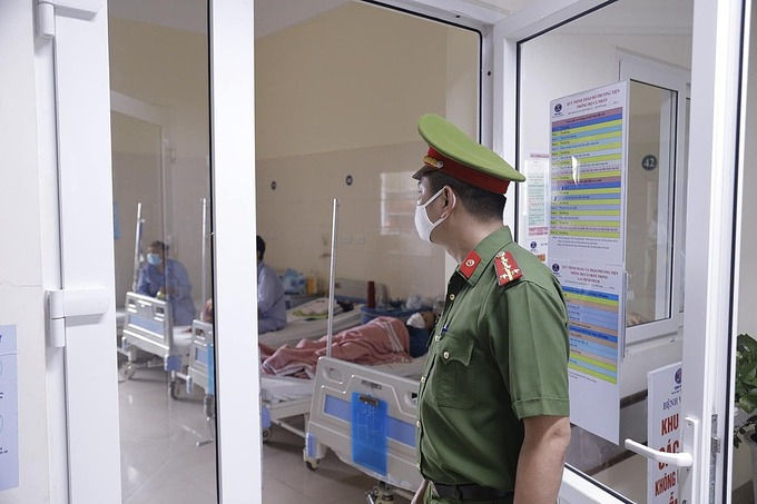 Bệnh viện K phối hợp với công an nhắc nhở bệnh nhân và người nhà đeo khẩu trang. Ảnh: Thái Hà.