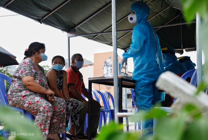 Người dân khu vực Thanh Đa, quận Bình Thạnh được lấy mẫu xét nghiệm, do có ca nghi nhiễm liên quan Hội thánh Truyền giáo Phục hưng tại quận Gò Vấp, sáng 27/5. Ảnh: Hữu Khoa.