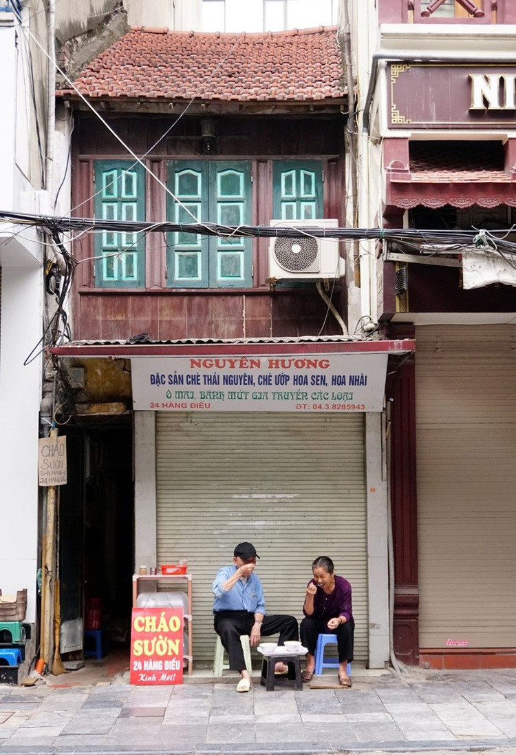 Hai cụ già ngồi ăn sáng trên phố Hàng Điếu.
