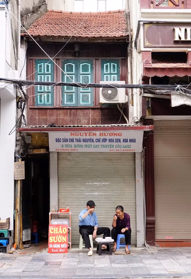 Hai cụ già ngồi ăn sáng trên phố Hàng Điếu.