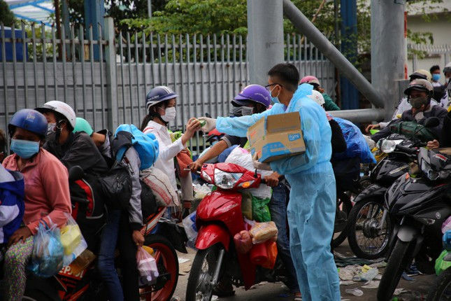 Lực lượng chức năng phát bánh mì, sữa và nước uống miễn phí cho người dân trong thời gian chờ địa phương bố trí vào khu vực tiếp nhận tạm thời, để sàng lọc. Các tỉnh miền Tây kiến nghị tạm ngưng cho người dân về quê tự phát ảnh 3