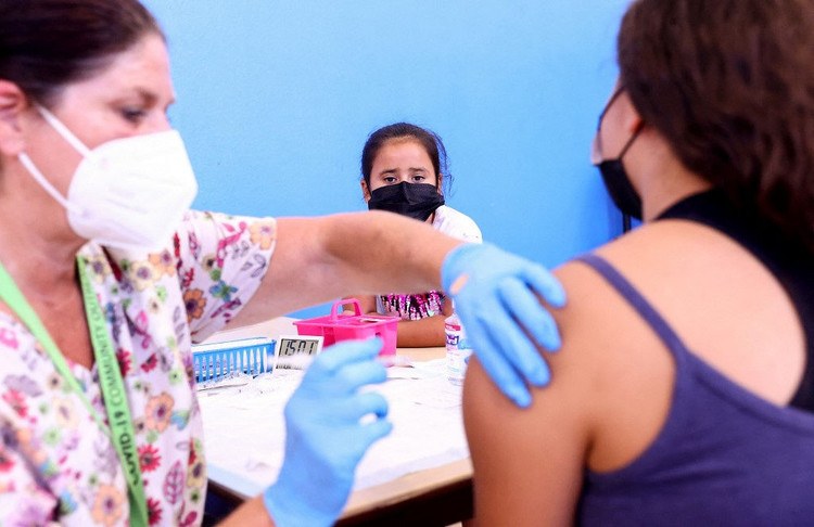 Một nữ sinh được tiêm vắc xin Covid-19 ở California, Mỹ /// AFP