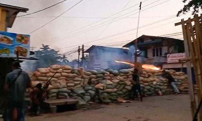 Người biểu tình cầm súng trường tự chế, nấp sau hàng rào bao cát ở thị trấn Bago, Myanmar hôm 9/4. Ảnh: AFP.