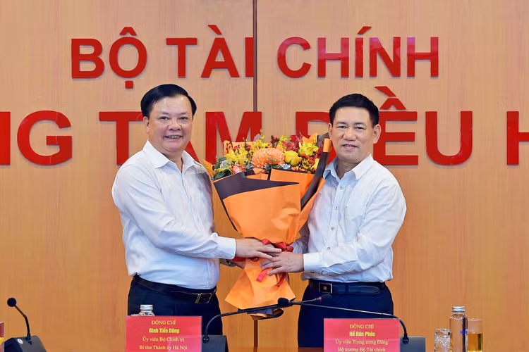 Đồng chí Đinh Tiến Dũng, Uỷ viên Bộ Chính trị, Bí thư Thành uỷ Hà Nội (nguyên Bộ trưởng Bộ Tài chính) bàn giao nhiệm vụ cho tân Bộ trưởng Tài chính Hồ Đức Phớc. Ảnh: VGP/HT