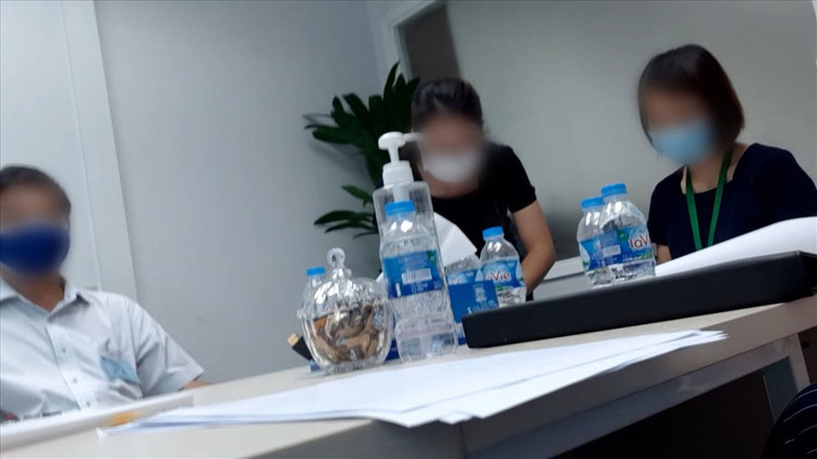 Nhân viên công ty BĐS Tiến Phước (thứ 2 từ trái sang) đang làm thủ tục mua bán cho người mua và người bán. Ảnh: Huân Cao