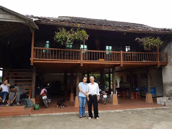 Bác Chài chụp ảnh lưu niệm với du khách đến ở homestay