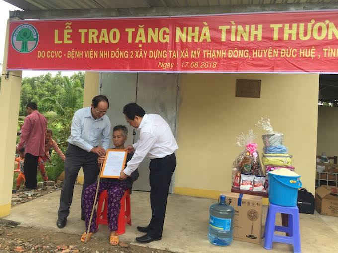 BS.CK II Trịnh Hữu Tùng – giám đốc Bệnh viện Nhi Đồng 2 TPHCM (tay phải) và ông Lê Văn Nên - Phó chủ tịch UBND huyện Đức Huệ, tỉnh Long An trao quyết định nhà tình thương cho bà Võ Thị Nời.