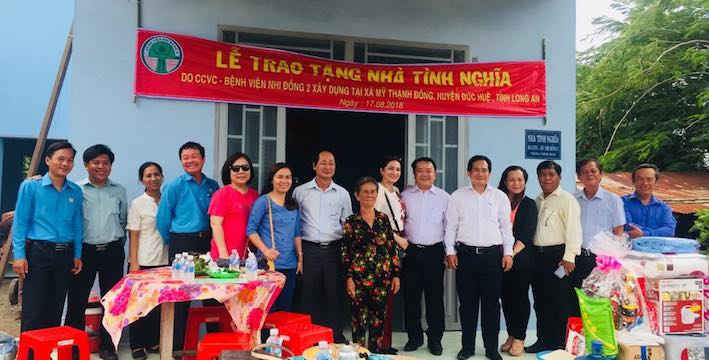 Đại diện Bệnh viện Nhi Đồng 2 TPHCM cùng lãnh đạo địa phương chụp hình cùng gia đình nhận nhà tình nghĩa.