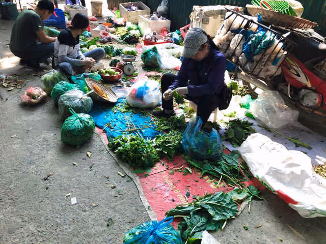 Quá trình sơ chế rau được diễn ra ngay tại điểm bán. Ảnh: Đỗ Dung