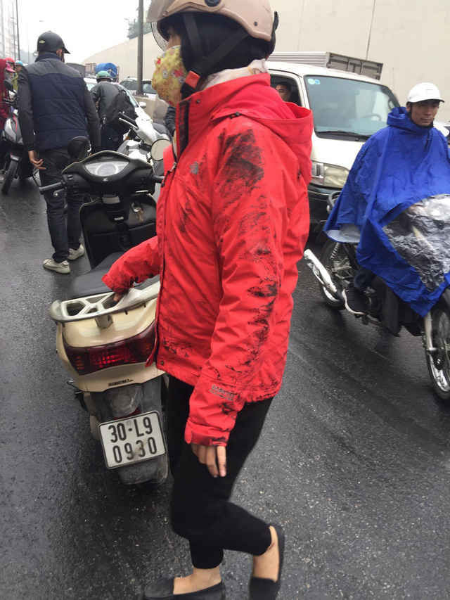 Một phụ nữ áo bám đầy dầu sau khi bị ngã.