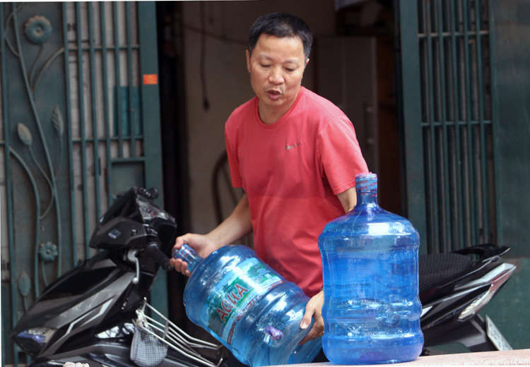 Nước đóng bình được chuyển đến nhà người dân ở Khương Đình, Thanh Xuân. Ảnh: Võ Hải.