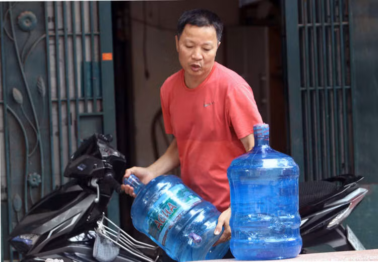 Nước đóng bình được chuyển đến nhà người dân ở Khương Đình, Thanh Xuân. Ảnh: Võ Hải.