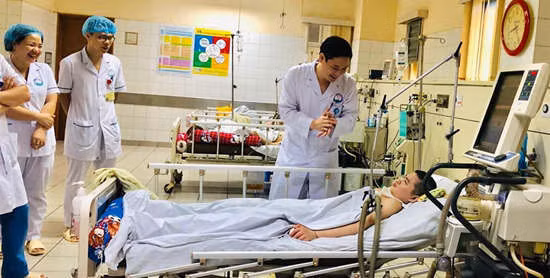 Các y&nbsp;bác sĩ đứng xung quanh giường bệnh&nbsp;cười hạnh phúc khi bệnh nhi hồi tỉnh. Ảnh do bác sĩ cung cấp.