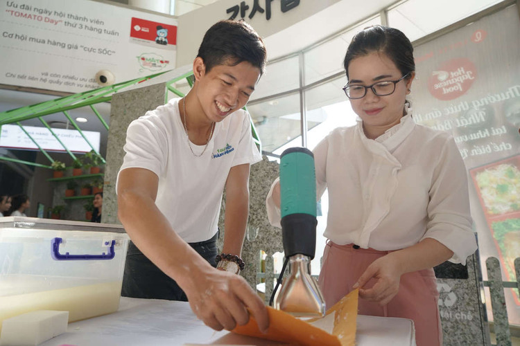 Người tiêu dùng trải nghiệm quy trình làm giấy tái chế tại sự kiện.