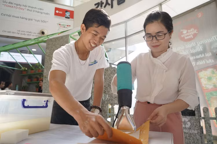 Người tiêu dùng trải nghiệm quy trình làm giấy tái chế tại sự kiện.