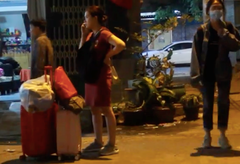 Cư dân tất tả dọn đồ ra khỏi căn hộ trong đêm 23/1. (Ảnh: Hải Long)